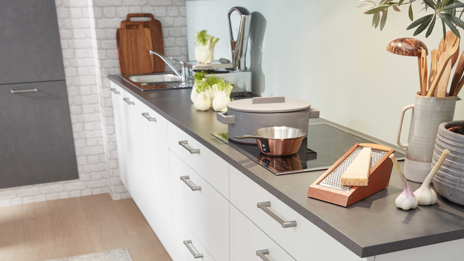 Einbauküche Interliving aus Holz in Grau Interliving Küche Serie 3019 mit AEG Einbaugeräten Weiß & Stahlgrau – zweizeilig