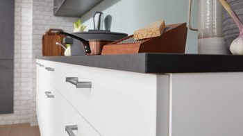 Einbauküche Interliving aus Holz in Grau Interliving Küche Serie 3019 mit AEG Einbaugeräten Weiß & Stahlgrau – zweizeilig