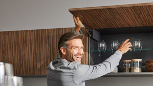 Einbauküche Interliving aus Holz in Schwarz Interliving Küche Serie 3108 mit Miele-Einbaugeräten Mattschwarz & Stripe Wood Choco - dreizeilig